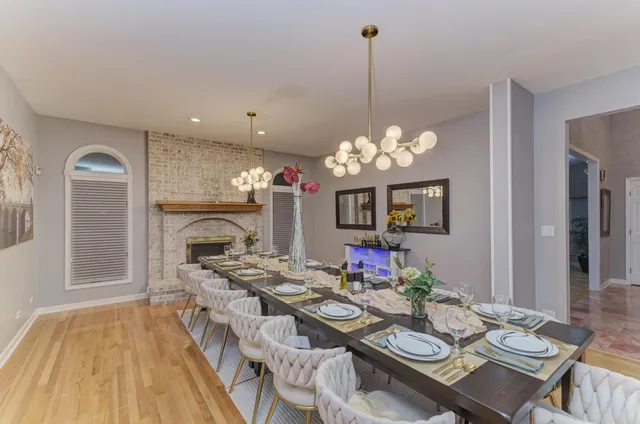 a view of a dining room with furniture a chandelier and wooden floor