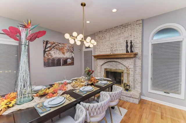 a view of a dining room with furniture a chandelier and wooden floor