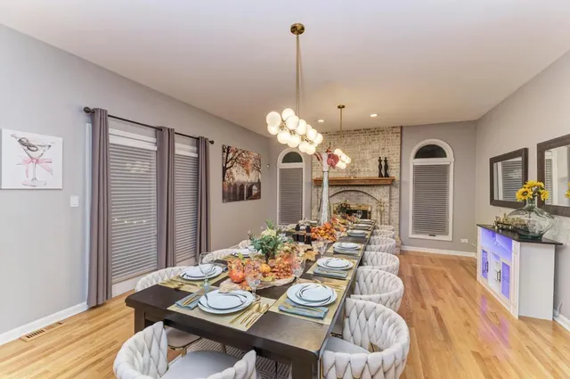 a view of a dining room with furniture a chandelier and wooden floor