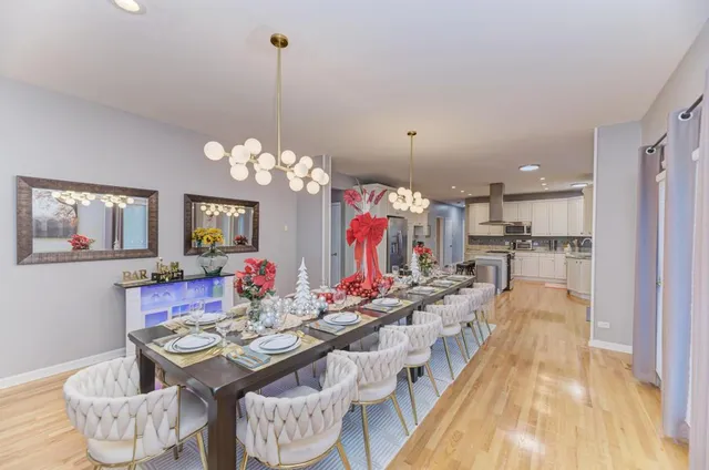a view of a dining room with furniture a chandelier and wooden floor