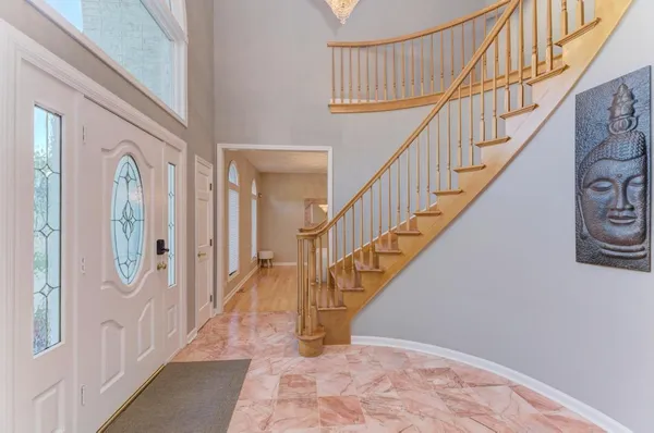 a view of staircase with wooden floor and a chandelier