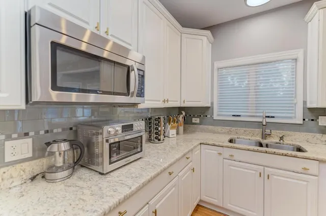 a living room with couches a table and a chandelier