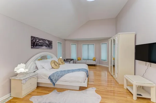 a bedroom with a bed and a flat tv screen on the dresser