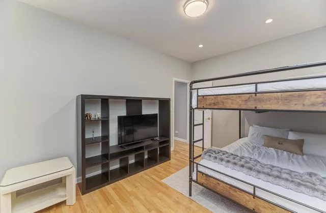 a bedroom with a bed and wooden floor