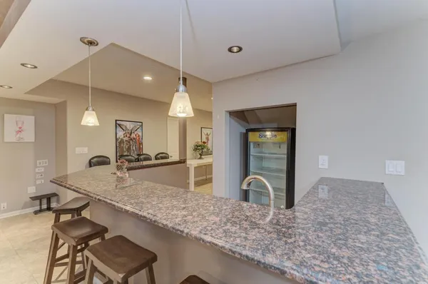 a view of a roof deck with table and chairs under an umbrella with wooden floor