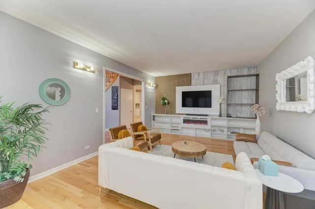 a view of a dining room and livingroom with furniture wooden floor a chandelier