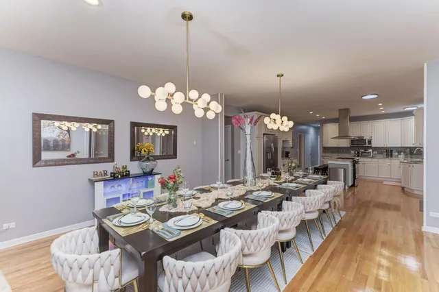a view of a dining room with furniture a chandelier and wooden floor