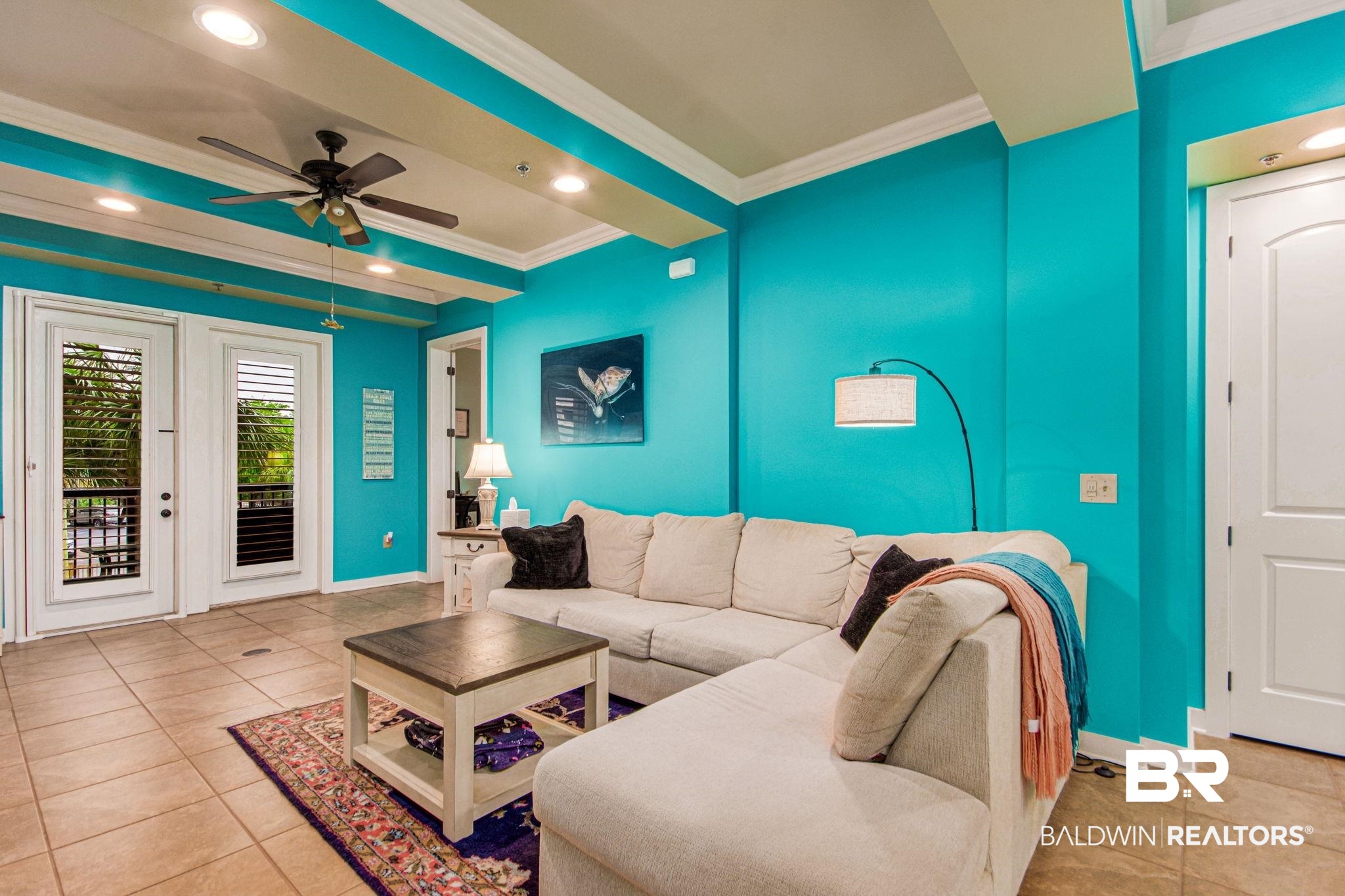 1430 Regency Road, Unit I201 Gulf Shores, AL 36542 - Photo 6 of 34 Living room featuring crown molding, ceiling fan, beamed ceiling, and light tile patterned flooring