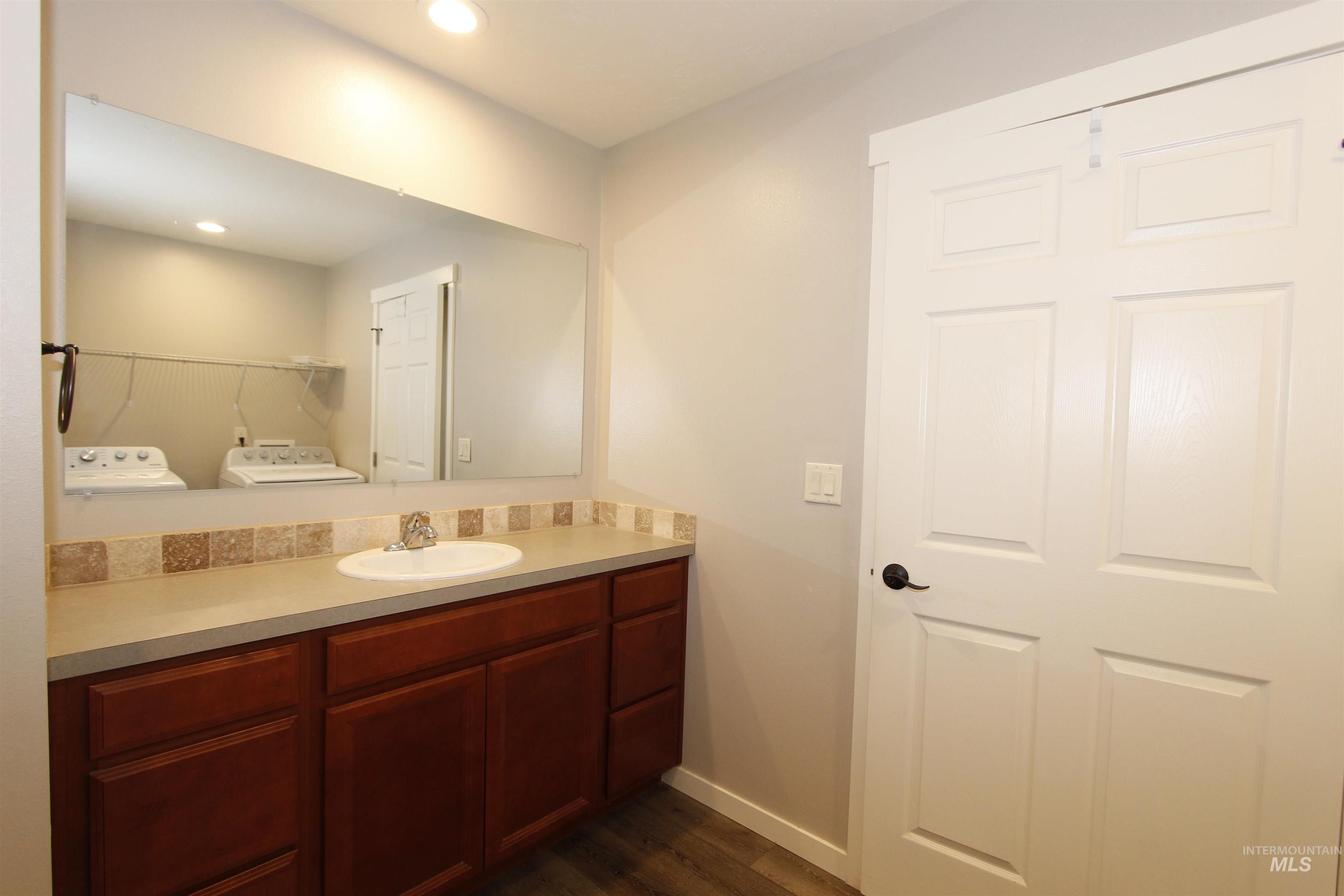 3434 5th Street, Unit B Lewiston, ID 83501 - Photo 13 of 19 Bathroom featuring vanity, dark wood-style floors, separate washer and dryer, and recessed lighting