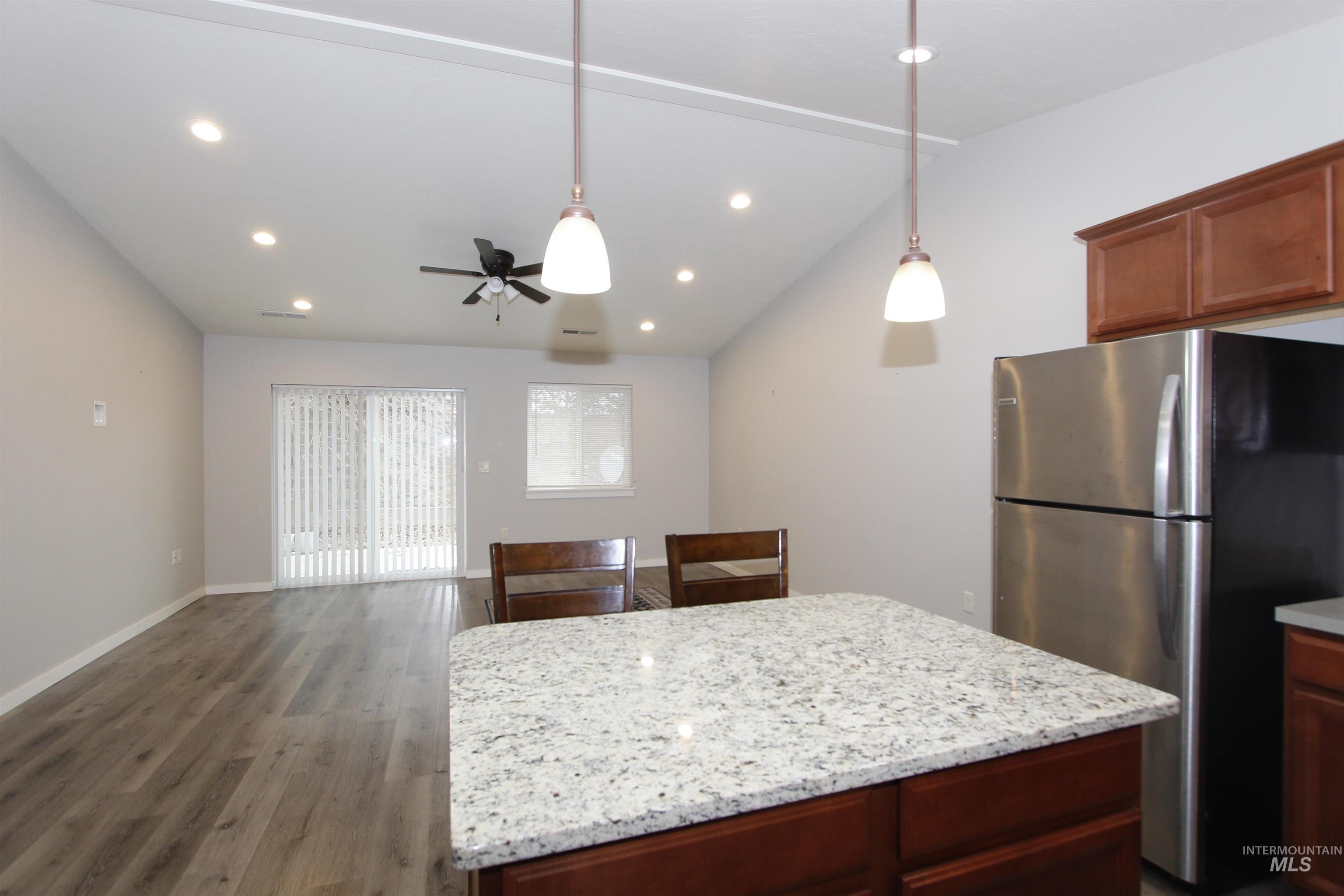 3434 5th Street, Unit B Lewiston, ID 83501 - Photo 19 of 19 Kitchen featuring freestanding refrigerator, a kitchen island, open floor plan, dark wood-type flooring, and pendant lighting