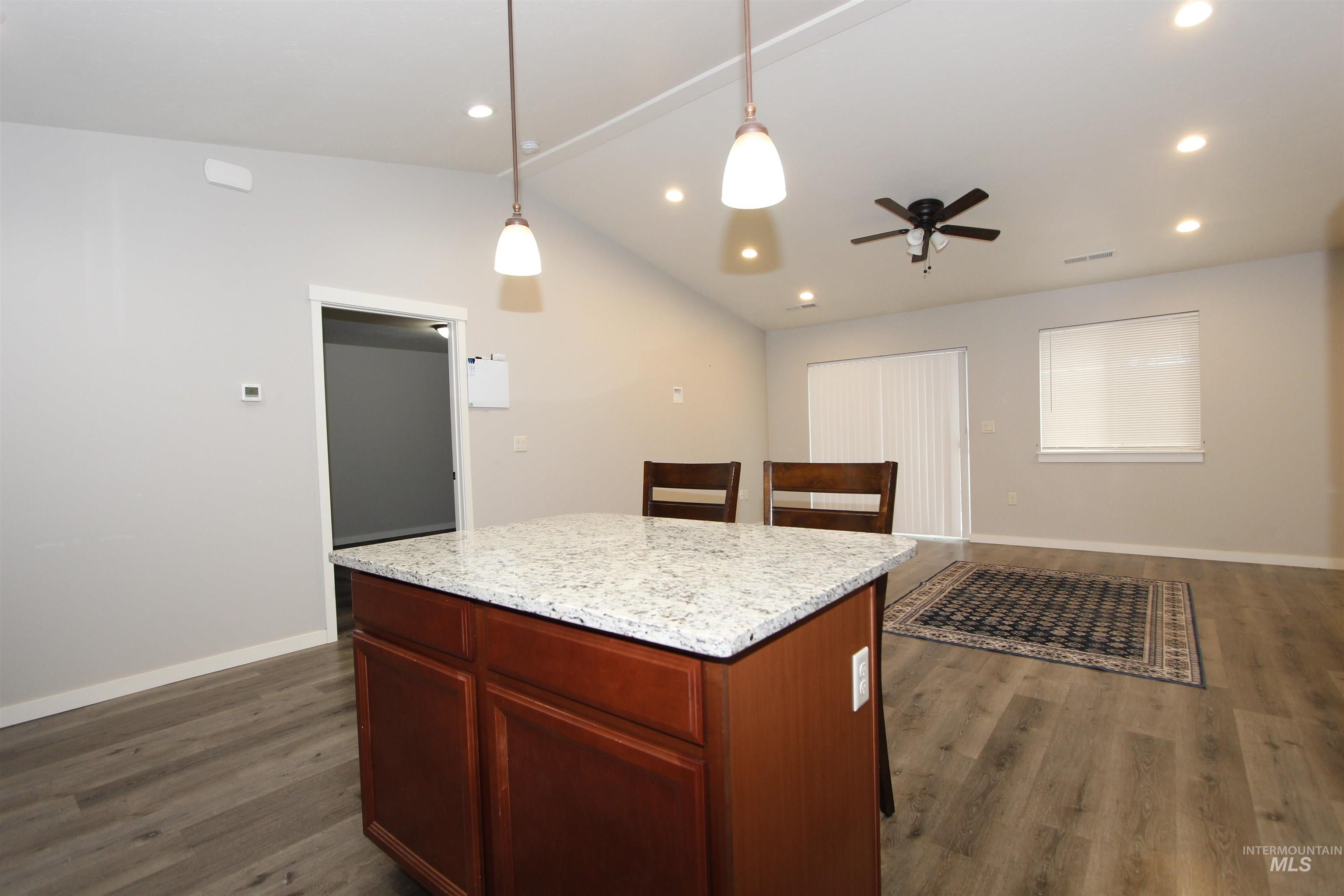 3434 5th Street, Unit B Lewiston, ID 83501 - Photo 4 of 19 Kitchen with vaulted ceiling, dark wood-type flooring, light stone counters, hanging light fixtures, and recessed lighting
