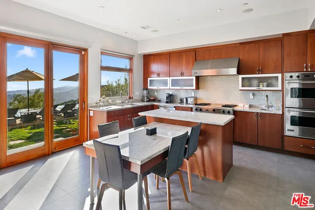 a kitchen with a dining table chairs and refrigerator