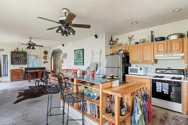 a very nice looking kitchen with a dining table chairs and a refrigerator