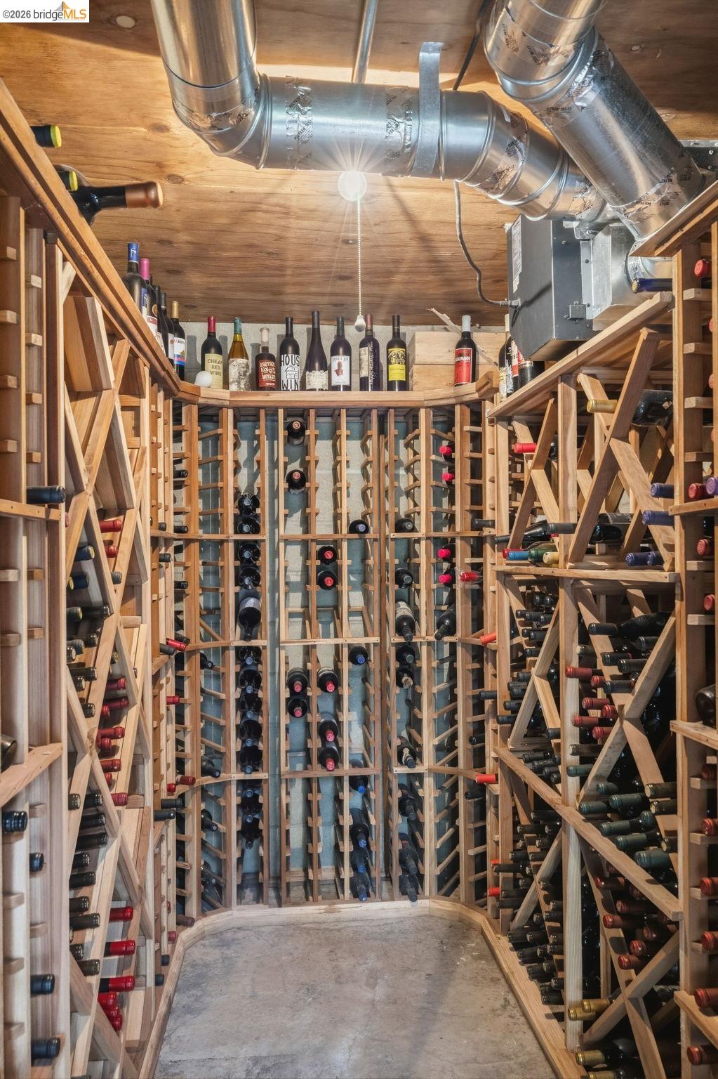18450 Lambert Lake Road Sonora, CA 95370 - Photo 61 of 87 Dedicated wine cellar featuring extensive wooden racking, exposed ductwork, concrete flooring, and a plywood ceiling