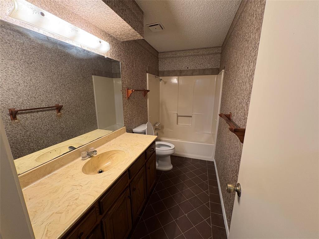 1838 West Taylor Street Sherman, TX 75092 - Photo 20 of 33 a bathroom with a sink a toilet a mirror and shower