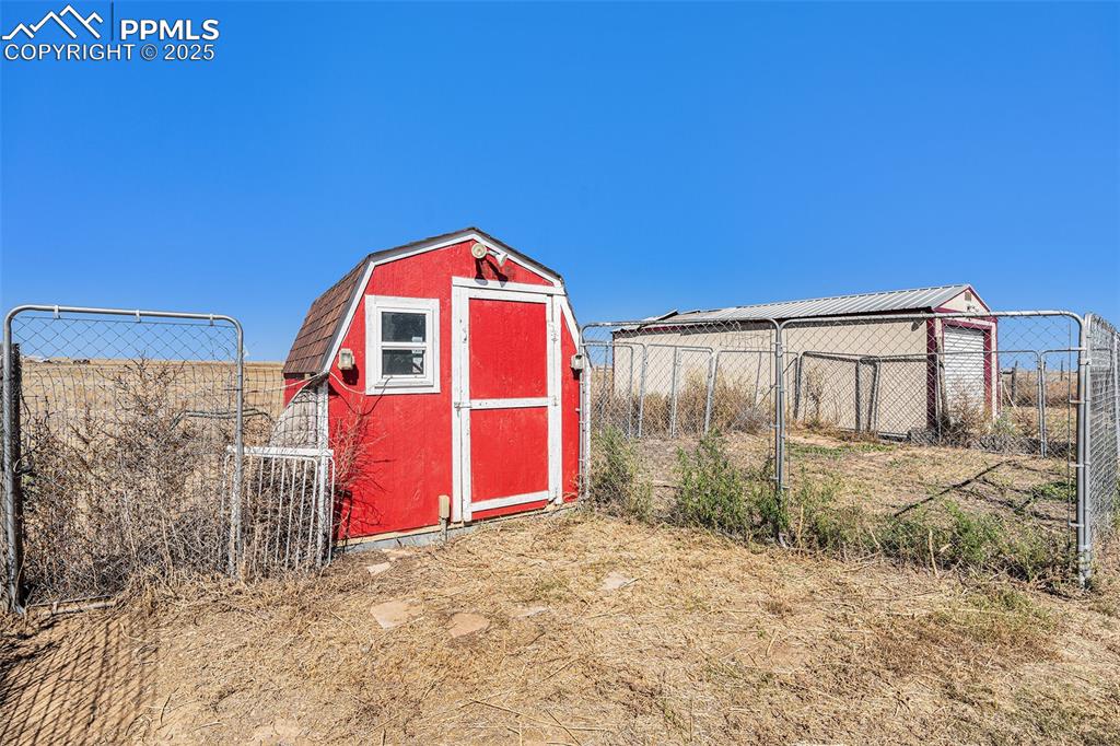 6855 Lauppe Road Yoder, CO 80864 - Photo 18 of 27 a view of a wooden house with a yard and large tree