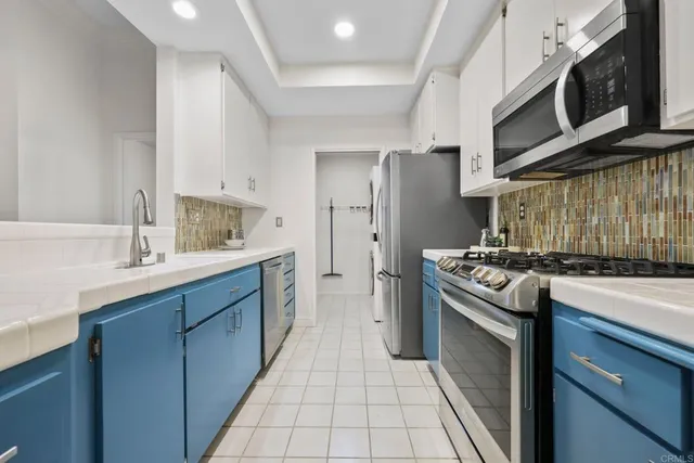 a kitchen with stainless steel appliances a sink stove and cabinets