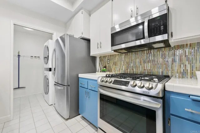 a kitchen with stainless steel appliances granite countertop a stove a refrigerator and a microwave