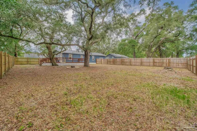 an empty room with wooden floor chandelier fan and windows