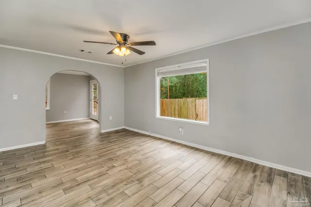 an empty room with a window and a fan