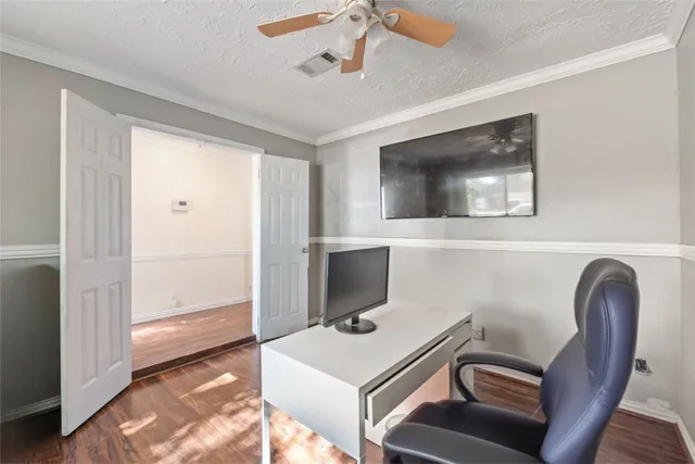 a room with a computer on a desk and chair