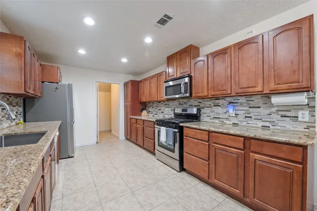 a kitchen with stainless steel appliances granite countertop a stove sink and cabinets