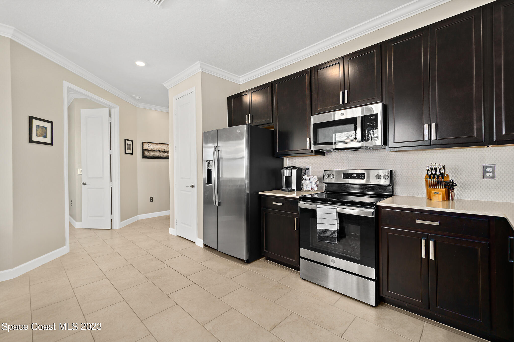 9753 Alister Drive Melbourne, FL 32940 - Photo 11 of 42 a kitchen with stainless steel appliances granite countertop a refrigerator and a stove top oven