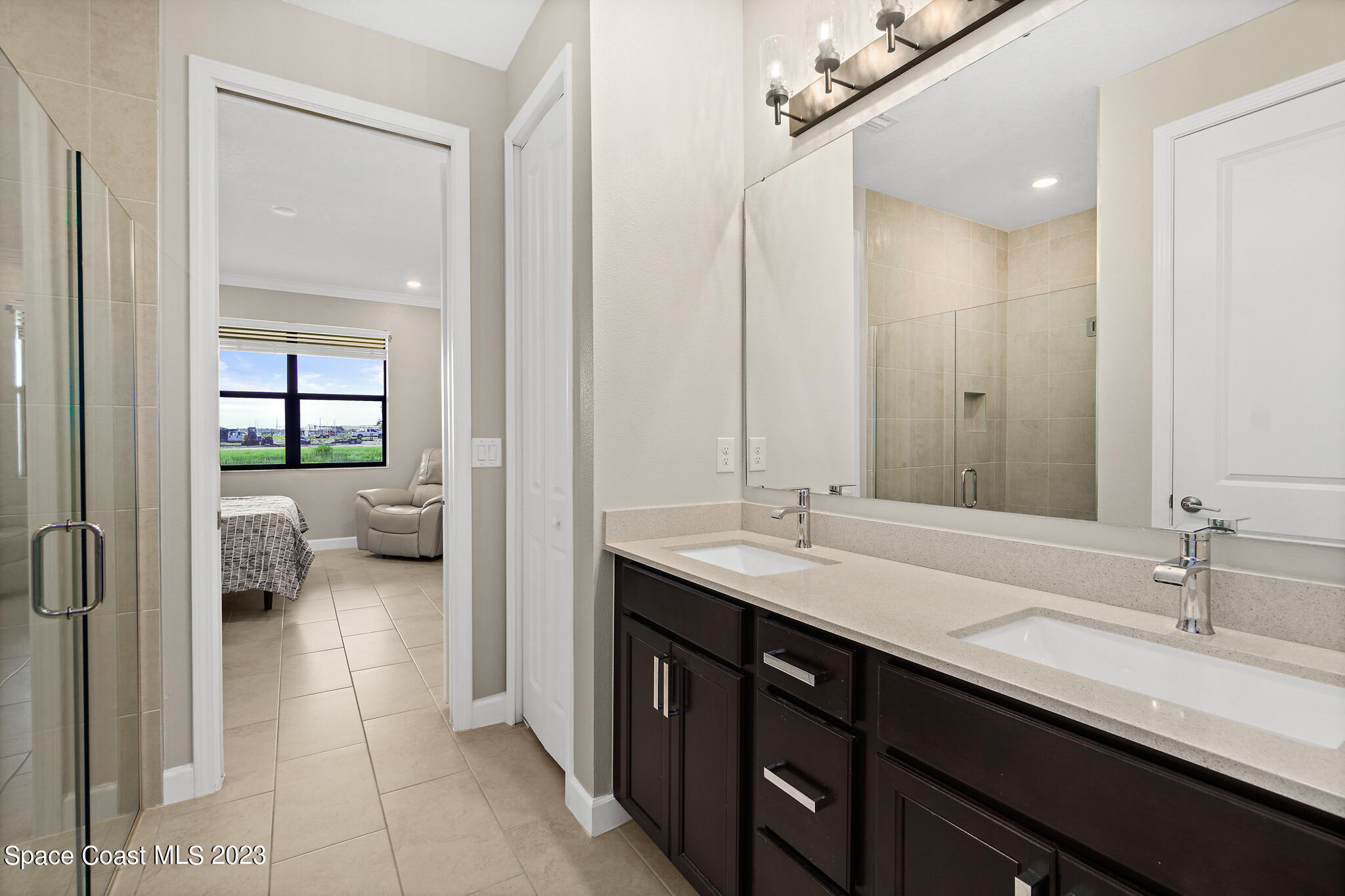 9753 Alister Drive Melbourne, FL 32940 - Photo 13 of 42 a en suite bathroom with a sink double vanity and a large mirror