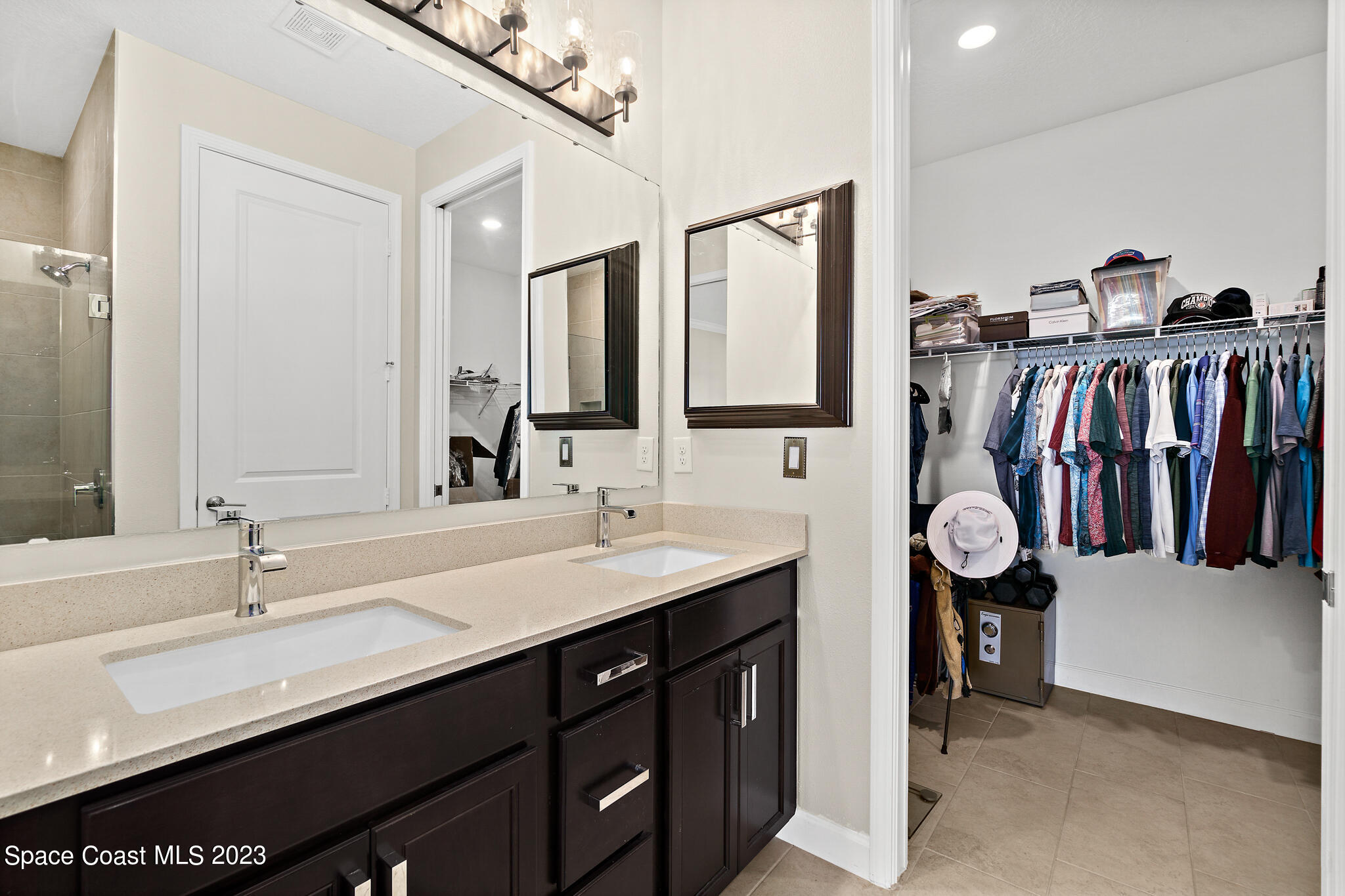 9753 Alister Drive Melbourne, FL 32940 - Photo 15 of 42 a bathroom with a double vanity sink and a mirror