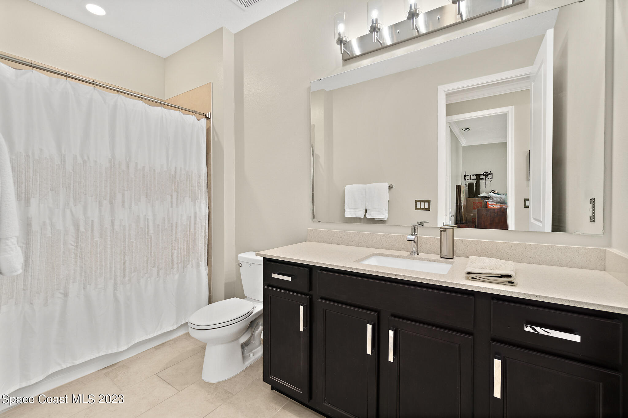 9753 Alister Drive Melbourne, FL 32940 - Photo 17 of 42 a bathroom with a double vanity sink toilet and a mirror