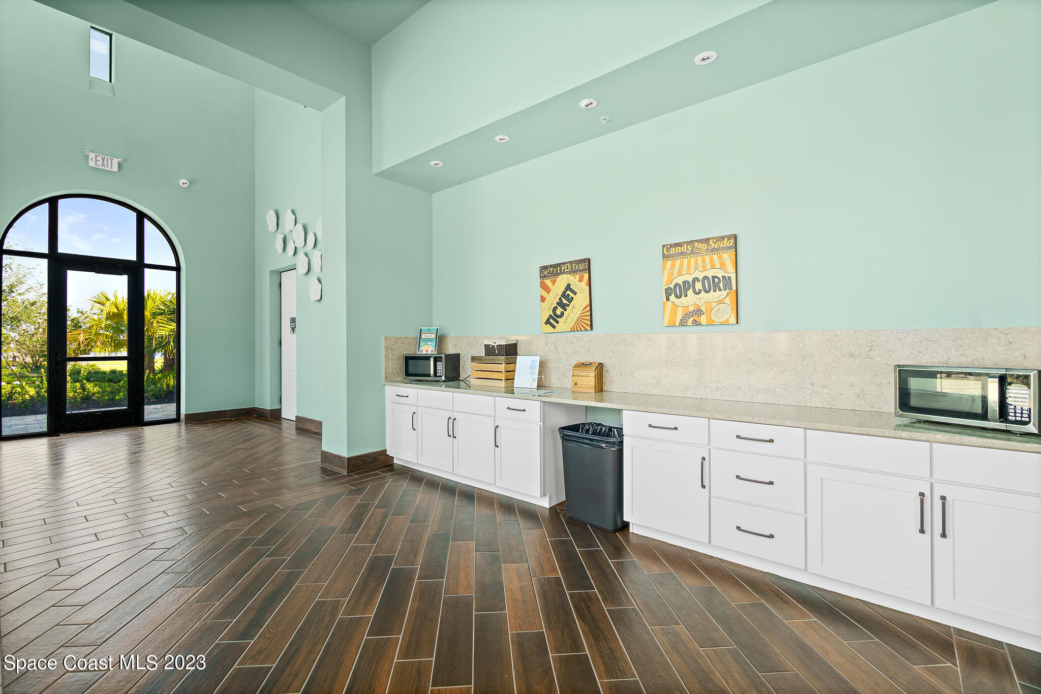 9753 Alister Drive Melbourne, FL 32940 - Photo 32 of 42 a large white kitchen with wooden floors and glass door