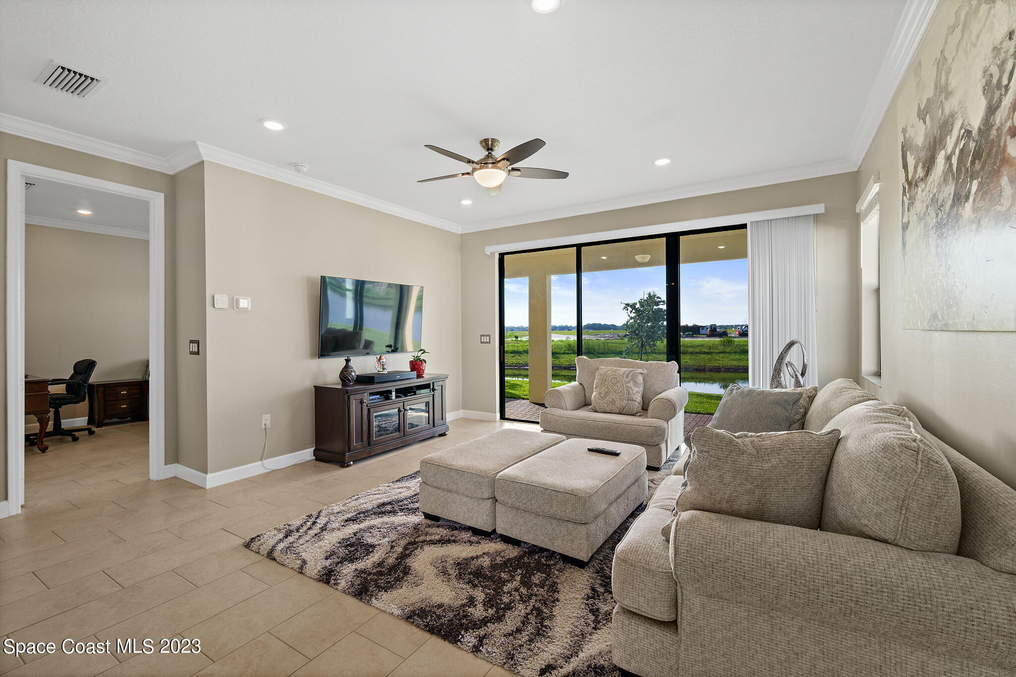 9753 Alister Drive Melbourne, FL 32940 - Photo 7 of 42 a living room with furniture large window and a flat screen tv