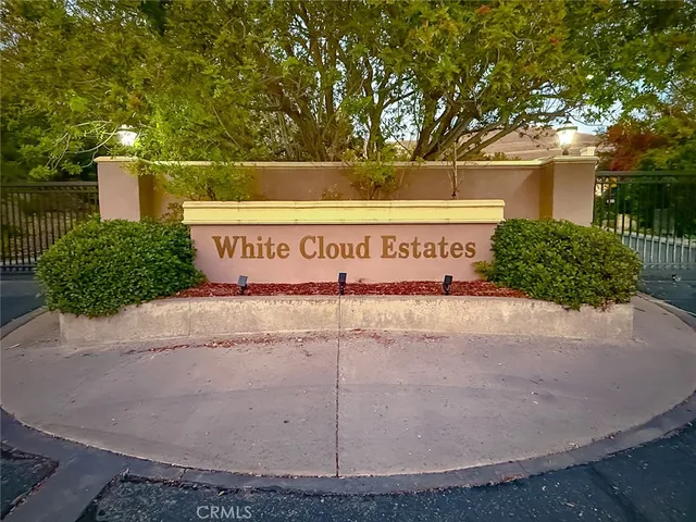 a large kitchen with stainless steel appliances granite countertop a refrigerator a sink dishwasher a stove with white cabinets and wooden floor