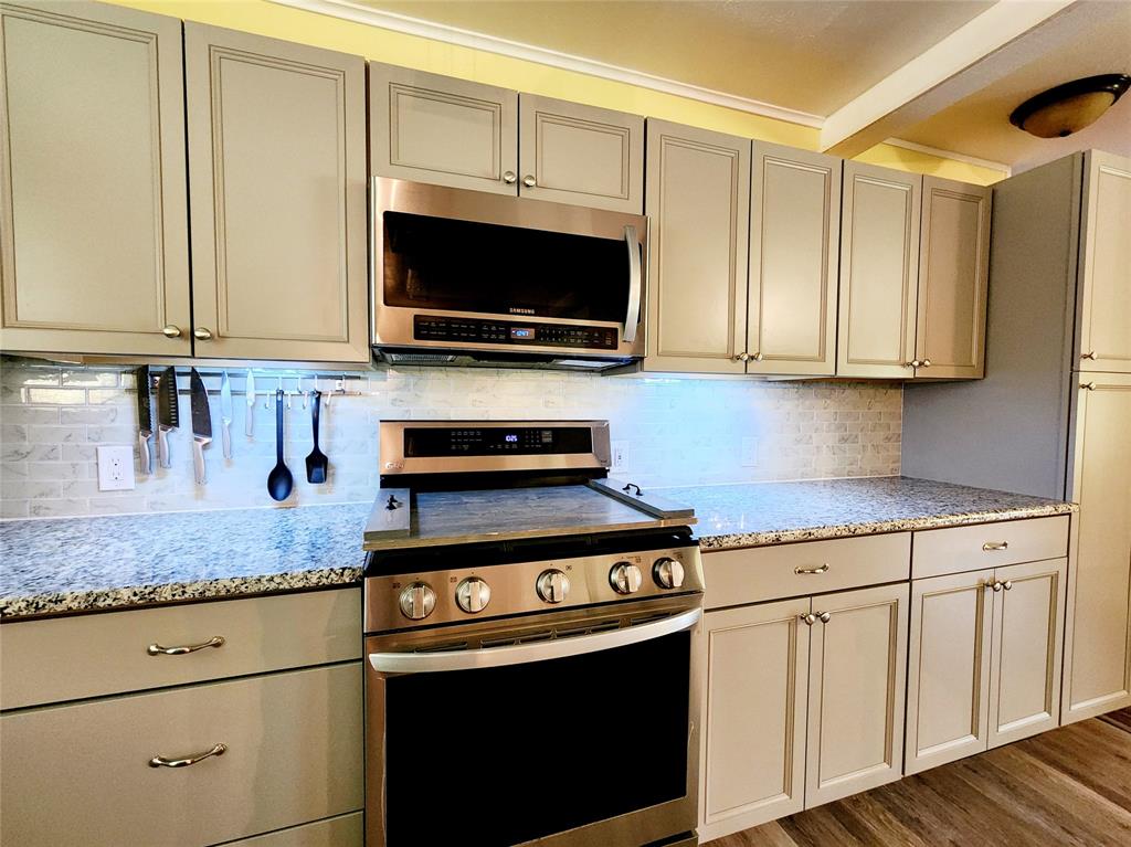 3514 Buchanan Loop Road Texarkana, TX 75501 - Photo 11 of 40 a kitchen with stainless steel appliances granite countertop a sink a stove and a microwave
