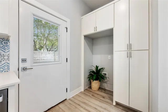 a view of a hallway with wooden floor and a potted plant