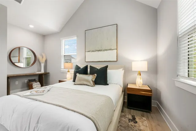 a bedroom with a bed a mirror and a window