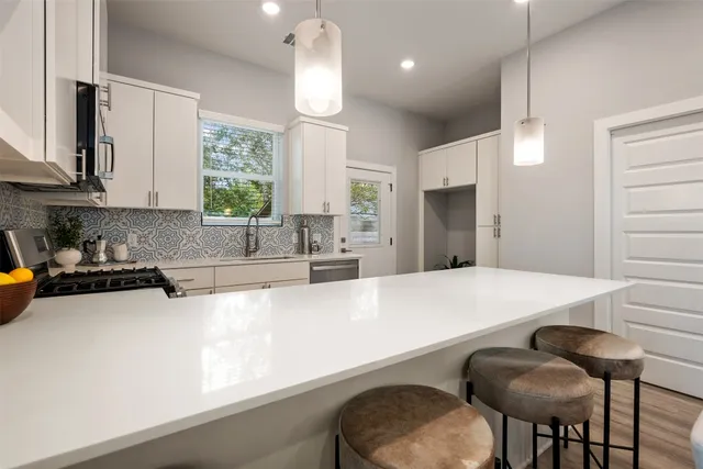 a kitchen with granite countertop a sink cabinets and window