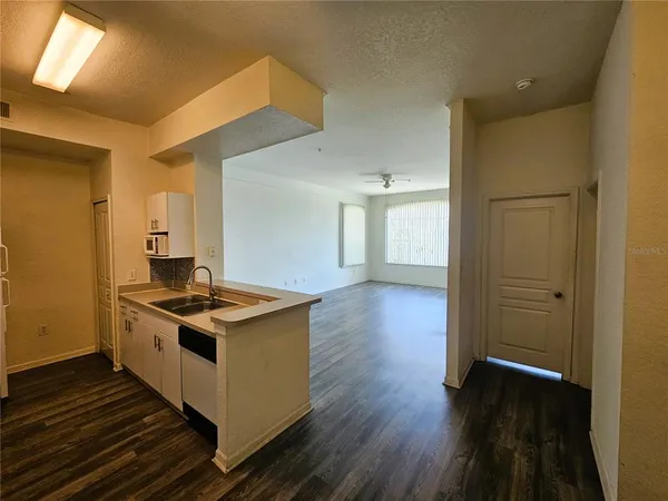 a kitchen with a refrigerator sink and white cabinets