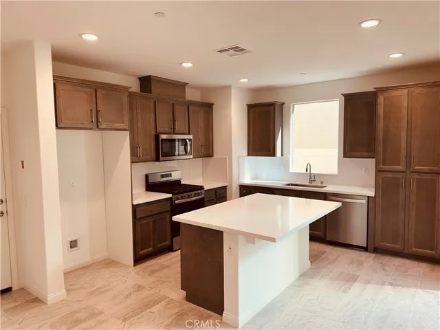 a kitchen with granite countertop a refrigerator and a sink