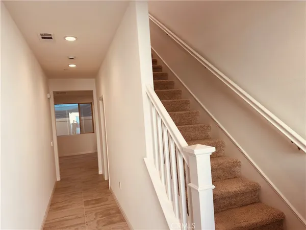 a view of a hallway with wooden floor and staircase