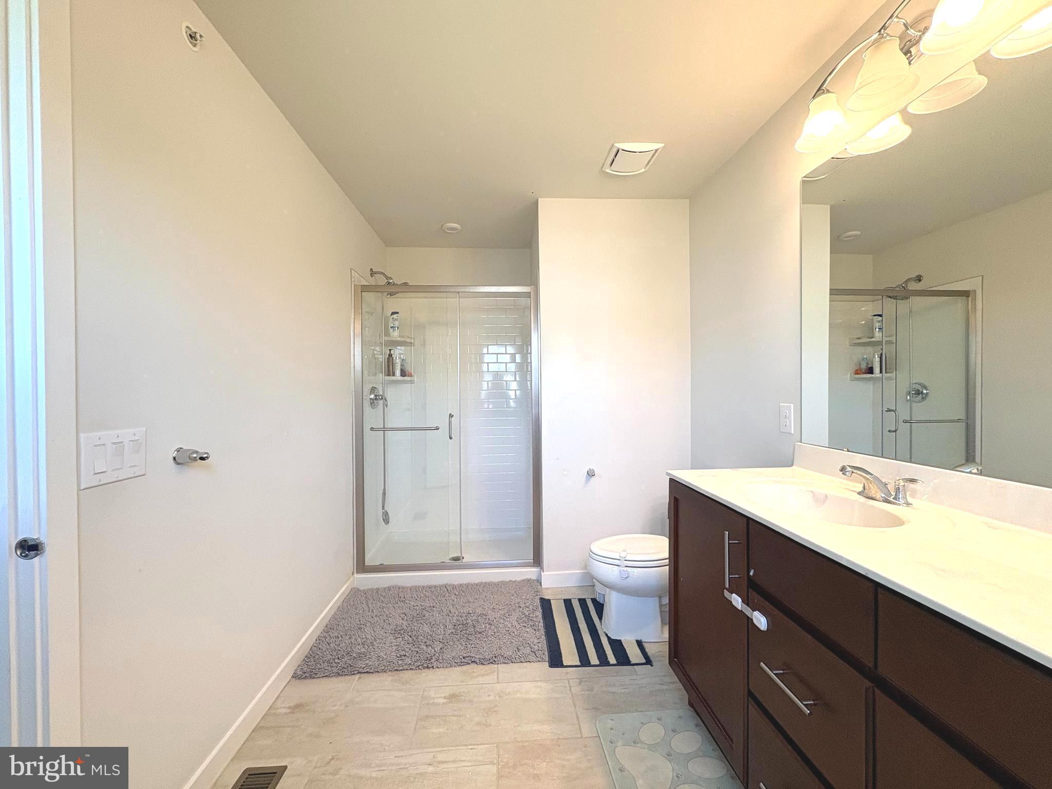 113 Wynstone Court Colmar, PA 18915 - Photo 11 of 20 a bathroom with a sink a toilet a large mirror and shower