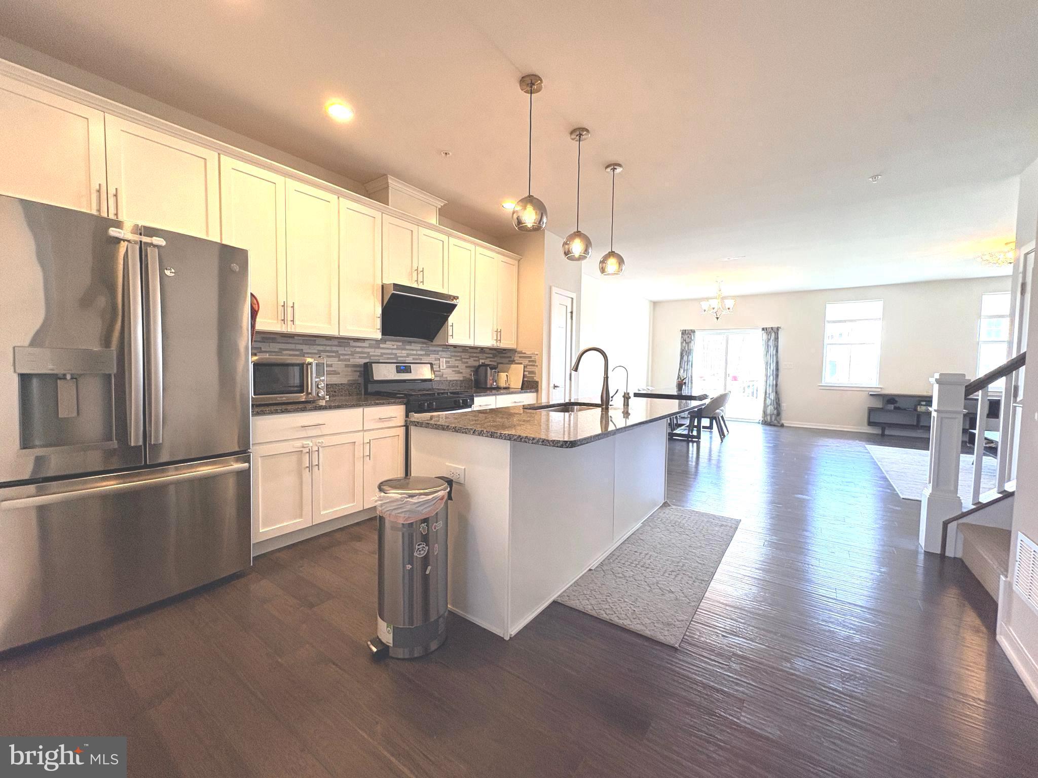 113 Wynstone Court Colmar, PA 18915 - Photo 4 of 20 a kitchen with stainless steel appliances granite countertop a refrigerator a stove and a sink with wooden floor