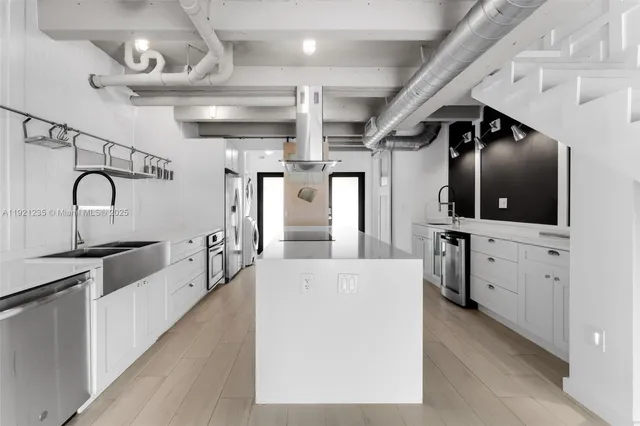 a large kitchen with cabinets and stainless steel appliances