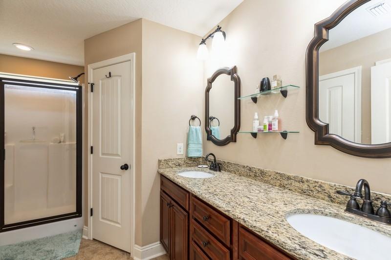 2693 Hartman Court Navarre, FL 32566 - Photo 22 of 34 a bathroom with a granite countertop sink mirror and vanity