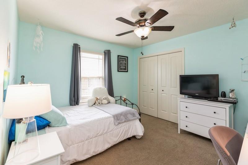 2693 Hartman Court Navarre, FL 32566 - Photo 24 of 34 a spacious bedroom with a bed and a flat screen tv