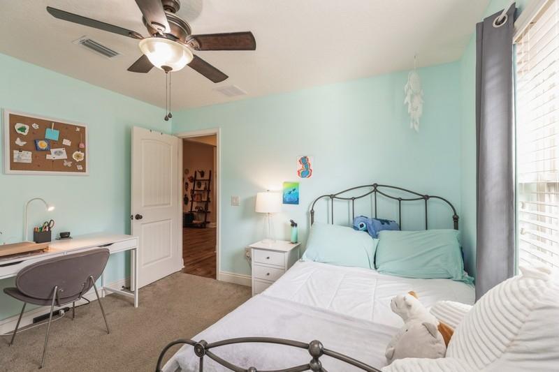 2693 Hartman Court Navarre, FL 32566 - Photo 25 of 34 a bedroom with a bed and a chandelier