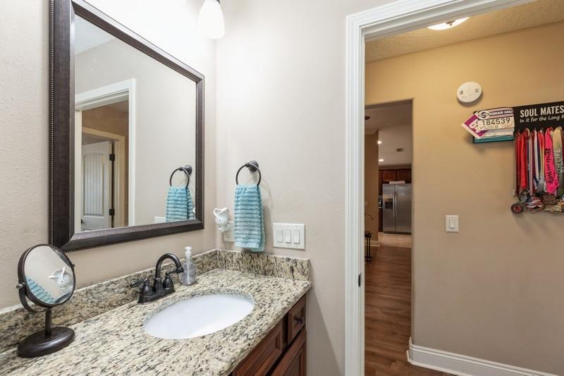 2693 Hartman Court Navarre, FL 32566 - Photo 29 of 34 a bathroom with a granite countertop sink and a mirror