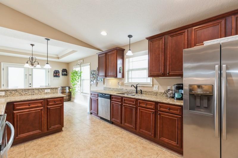 2693 Hartman Court Navarre, FL 32566 - Photo 10 of 34 a kitchen with stainless steel appliances granite countertop a refrigerator a sink dishwasher a stove with wooden cabinets and floor