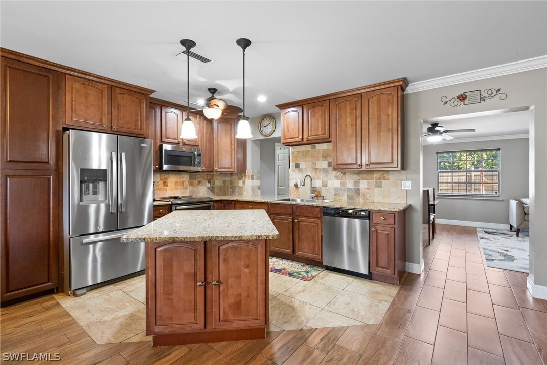 1447 Collins Road Fort Myers, FL 33919 - Photo 11 of 34 a kitchen with stainless steel appliances granite countertop a refrigerator a sink dishwasher a stove with wooden floor