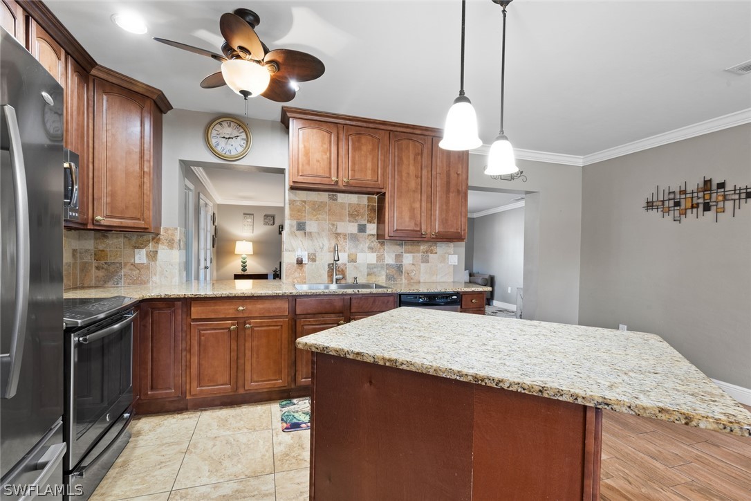 1447 Collins Road Fort Myers, FL 33919 - Photo 13 of 34 a kitchen with a kitchen island a clock and cabinets